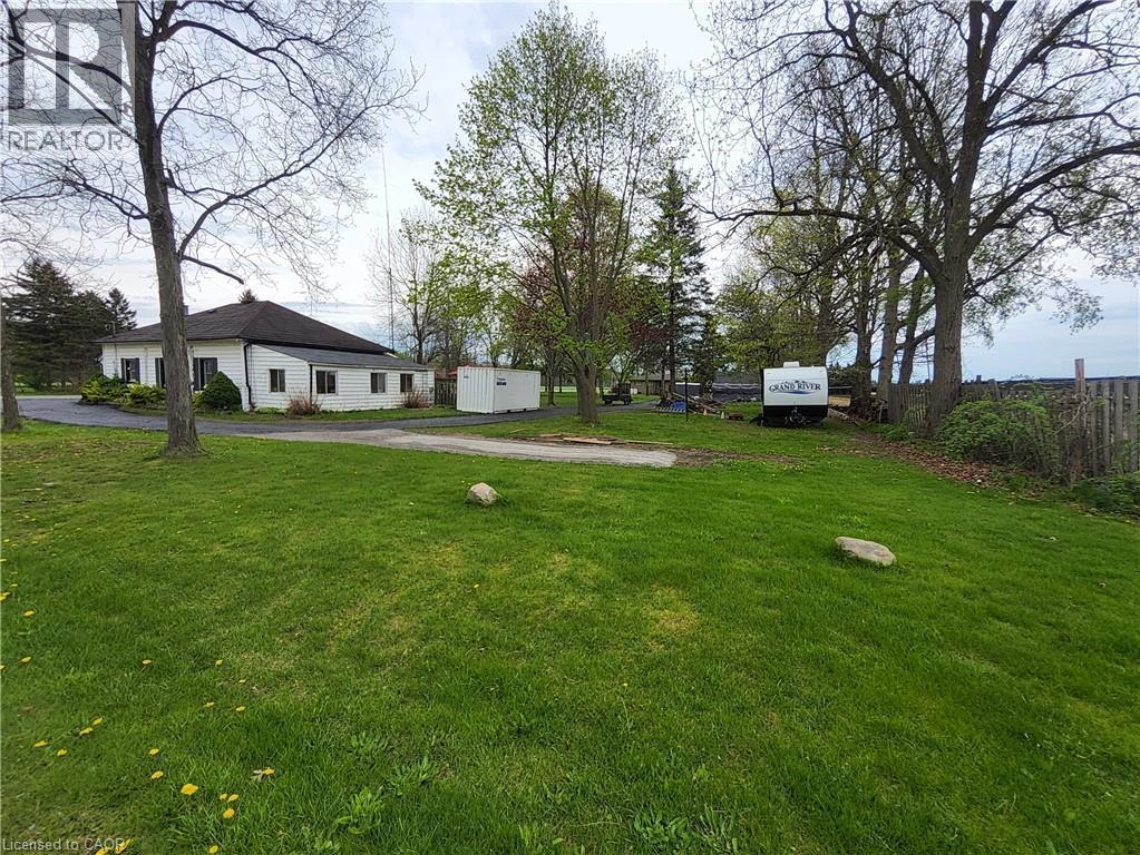 Spacious green lawn surrounding a white-sided residence with a dark roof - 740 Hillcrest Road, Simcoe, ON - Outdoor