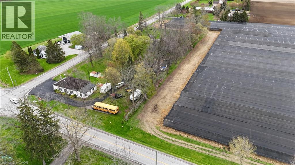 Aerial perspective showcasing a single-story structure with a dark roof and a surrounding paved area, positioned alongside a road - 740 Hillcrest Road, Simcoe, ON - Outdoor With View