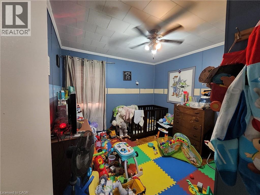 Bedroom featuring a nursery area, crown molding, and ceiling fan - 740 Hillcrest Road, Simcoe, ON - Indoor Photo Showing Other Room