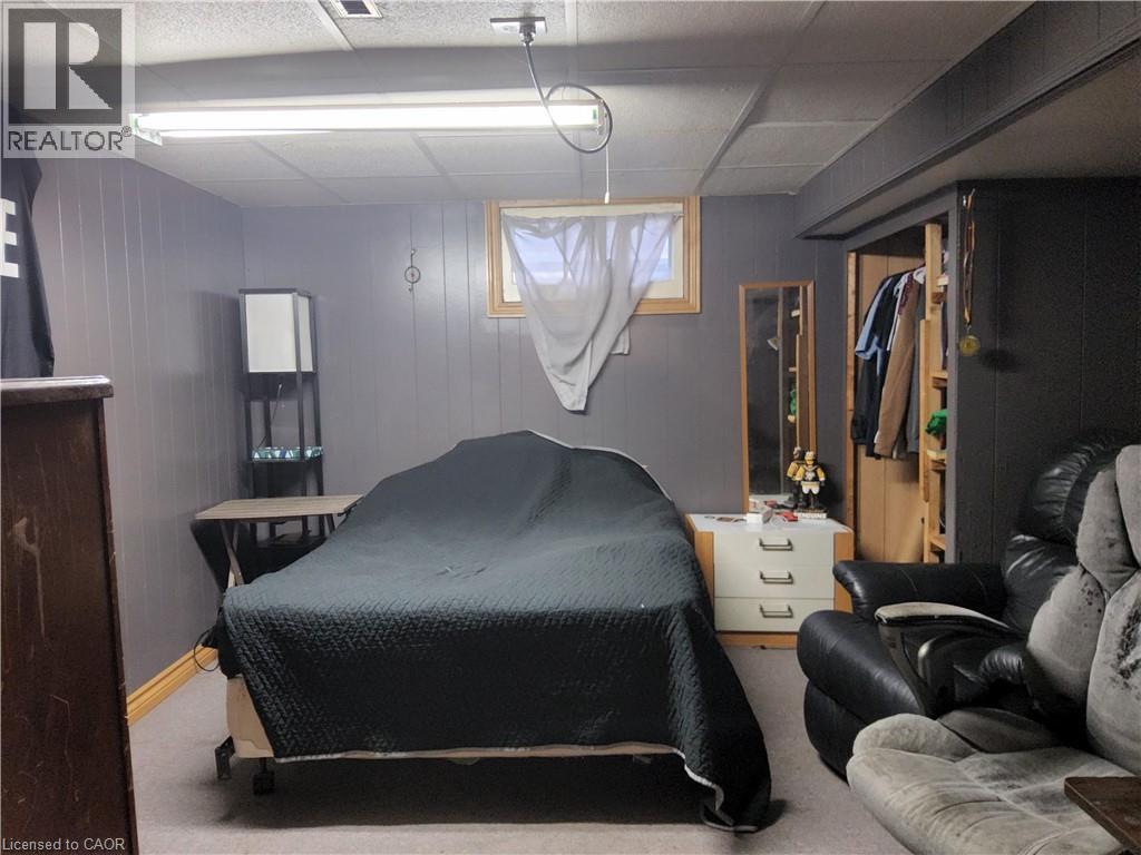 Bedroom with carpet floors, wooden walls, and a drop ceiling - 509 Queensway W, Simcoe, ON - Indoor Photo Showing Bedroom