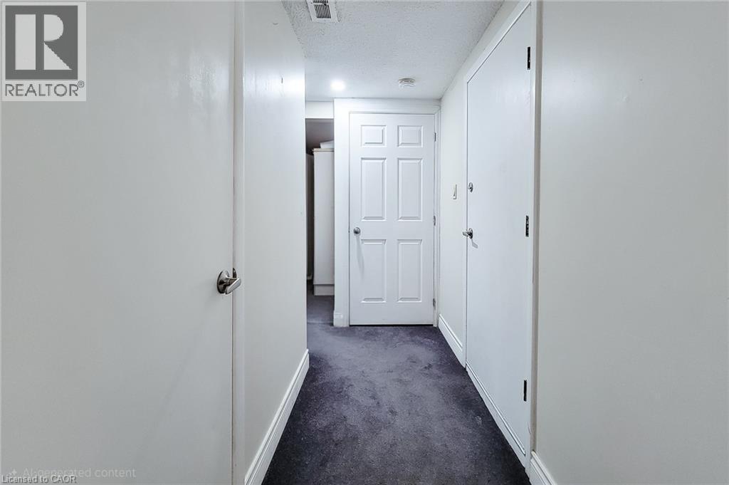 Corridor with dark colored carpet and a textured ceiling - 758 Stone Church Road E, Hamilton, ON - Indoor Photo Showing Other Room