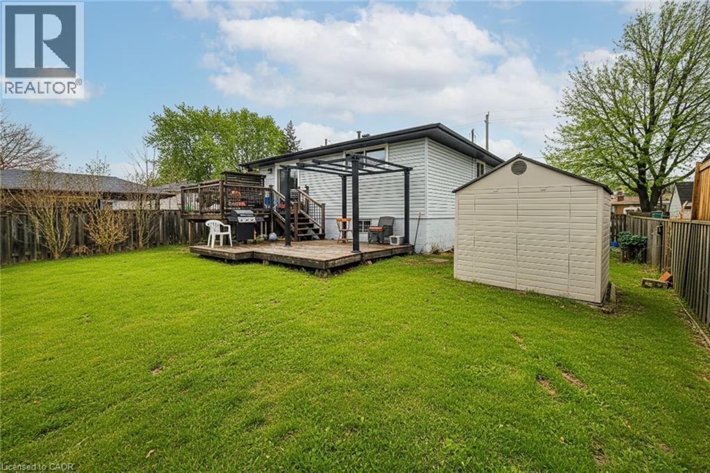 Back of property with a fenced backyard, a storage unit, and a deck - 758 Stone Church Road E, Hamilton, ON - Outdoor