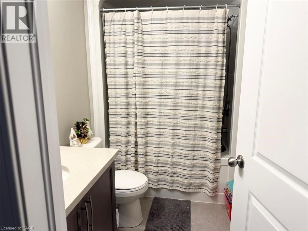 Bathroom with vanity, light tile patterned floors, and shower / bath combo - 65 Old School Trail Unit# 36, Welland, ON - Indoor Photo Showing Bathroom