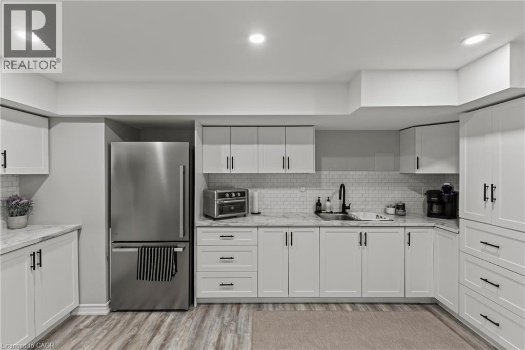 Kitchen with freestanding refrigerator, white cabinetry, light wood finished floors, light stone counters, and recessed lighting - 62 Esther Crescent Unit# Lower, Thorold, ON - Indoor Photo Showing Kitchen With Upgraded Kitchen