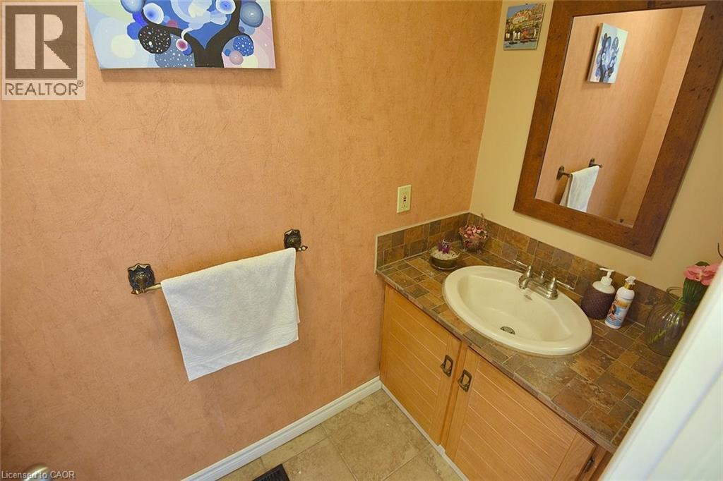 Bathroom featuring vanity, light tile patterned flooring, and tasteful backsplash - 43 Niska Drive, Waterdown, ON - Indoor Photo Showing Bathroom