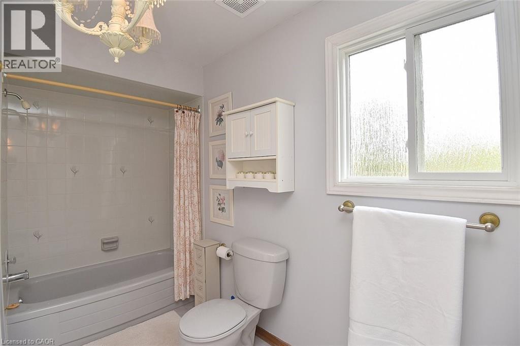 Full bath featuring shower / bath combination with curtain and a chandelier - 43 Niska Drive, Waterdown, ON - Indoor Photo Showing Bathroom