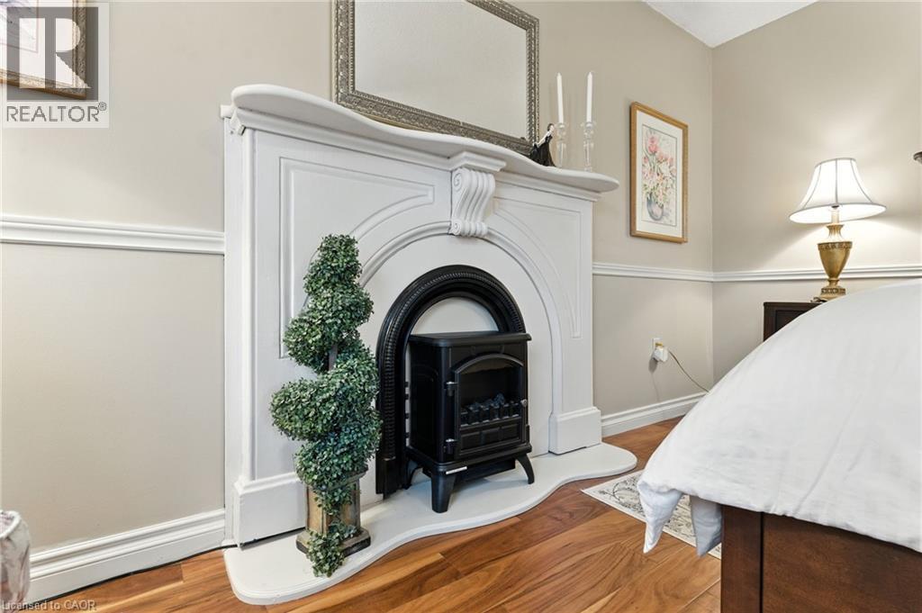 Detailed view of wood finished floors and a decorative fireplace - 3 Atkins Drive, Hamilton, ON - Indoor Photo Showing Bedroom