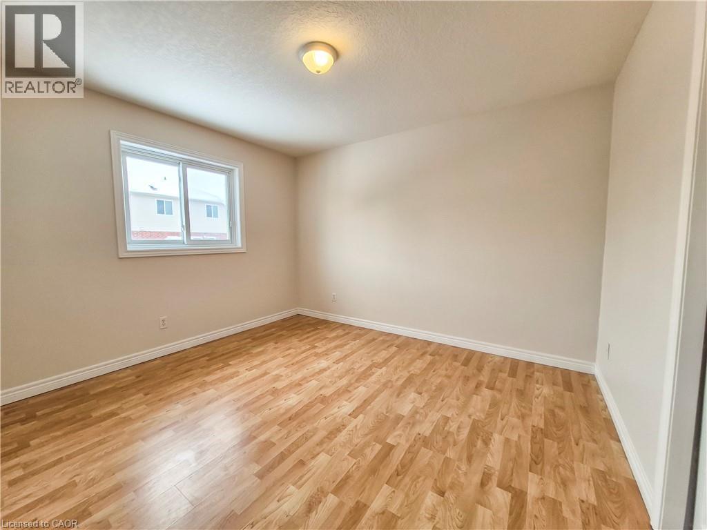 Unfurnished room featuring light wood finished floors and a textured ceiling - 132 Udvari Crescent Unit# 3, Kitchener, ON - Indoor Photo Showing Other Room