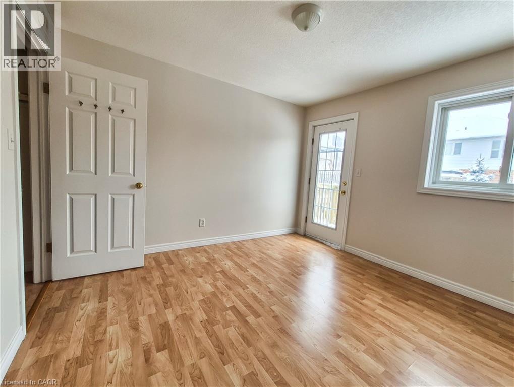 Spare room featuring light wood-type flooring and a textured ceiling - 132 Udvari Crescent Unit# 3, Kitchener, ON - Indoor Photo Showing Other Room