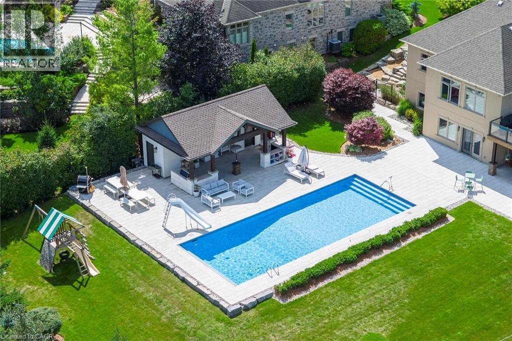 View of pool with a water slide, patio surround, an outbuilding, a storage structure, and an outdoor living / dining area - 86 Canters Close, Kitchener, ON - Outdoor With In Ground Pool