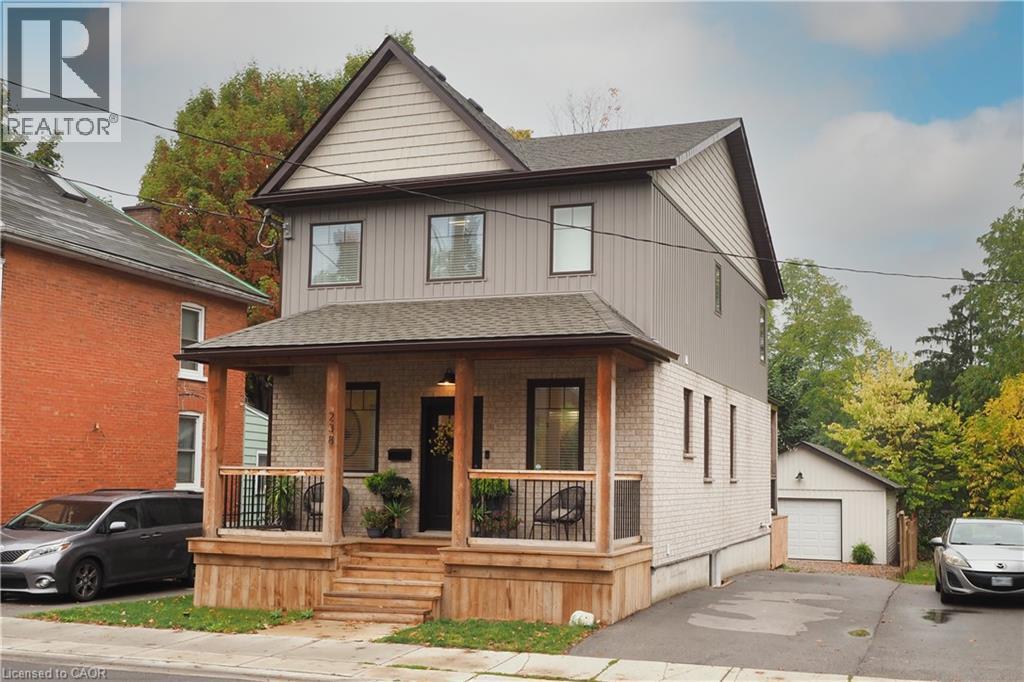 View of front of house featuring a shingled roof, covered porch, and brick siding - 238 Eagle Street S, Cambridge, ON - Outdoor With Deck Patio Veranda With Exterior