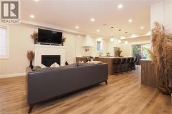 Living room with recessed lighting, light wood finished floors, and a glass covered fireplace -