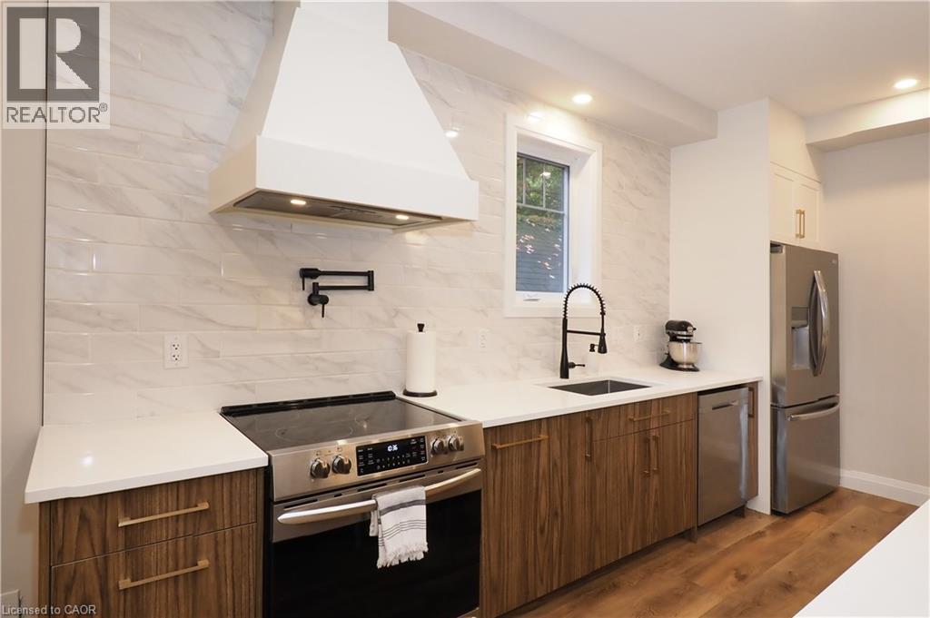 Kitchen with custom range hood, stainless steel appliances, modern cabinets, and dark wood finished floors - 238 Eagle Street S, Cambridge, ON - Indoor Photo Showing Kitchen With Upgraded Kitchen