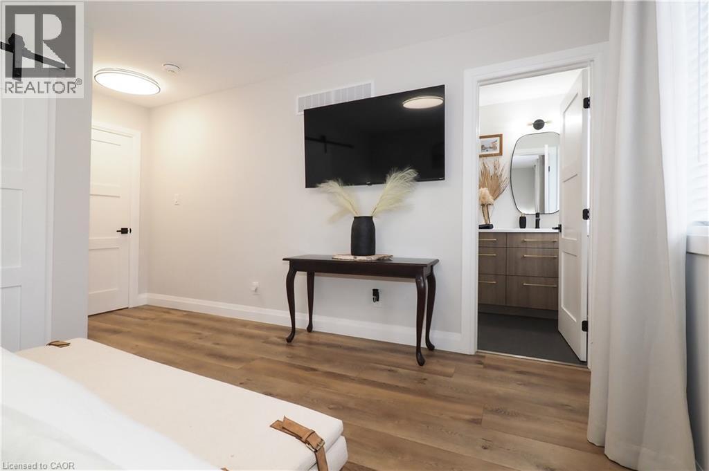 Bedroom with a barn door, dark wood-style flooring, and connected bathroom - 238 Eagle Street S, Cambridge, ON - Indoor Photo Showing Other Room
