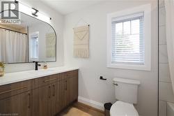Full bath with vanity, dark wood-style flooring, and healthy amount of natural light -