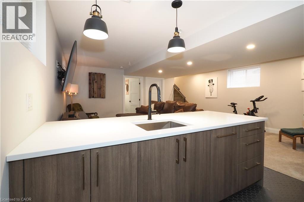 Kitchen featuring open floor plan, modern cabinets, hanging light fixtures, dark carpet, and recessed lighting - 238 Eagle Street S, Cambridge, ON - Indoor