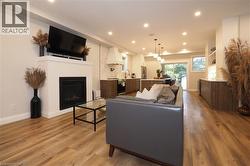 Living room with a fireplace, recessed lighting, and light wood-type flooring -