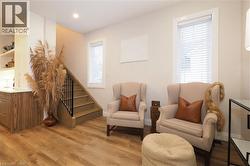 Sitting room featuring light wood-style flooring, stairs, and recessed lighting -