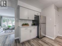 Kitchen featuring white cabinetry, light wood finished floors, and freestanding refrigerator -