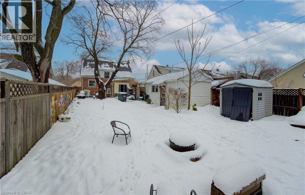 Yard layered in snow featuring a fenced backyard and a shed - 569 Stirling Avenue S, Kitchener, ON - Outdoor