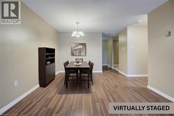 Dining room featuring a chandelier and dark wood finished floors -