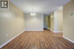 Empty room featuring wood finished floors and a chandelier -