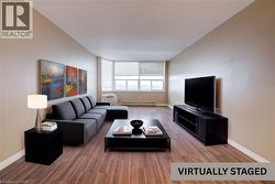 Living room featuring wood finished floors and a baseboard heating unit -