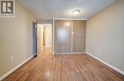 Unfurnished bedroom with wood finished floors, a textured ceiling, and a closet -