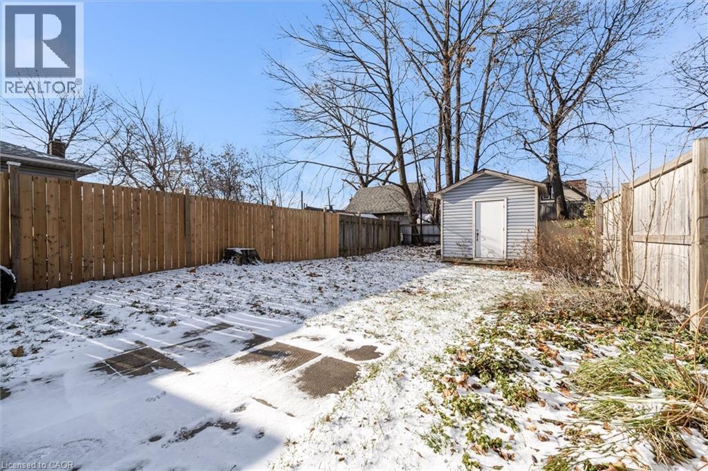 Snowy yard with a fenced backyard and a shed - 35 Bayfield Avenue, Hamilton, ON - Outdoor