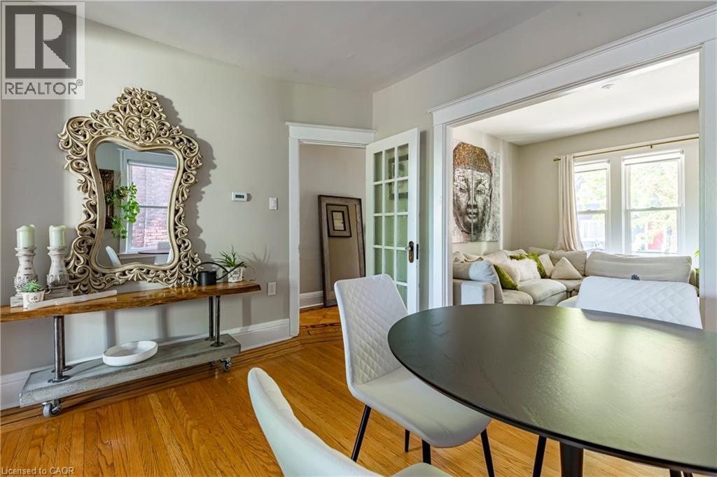 Dining area with light wood-style floors and french doors - 58 Chatham Street, Hamilton, ON - Indoor