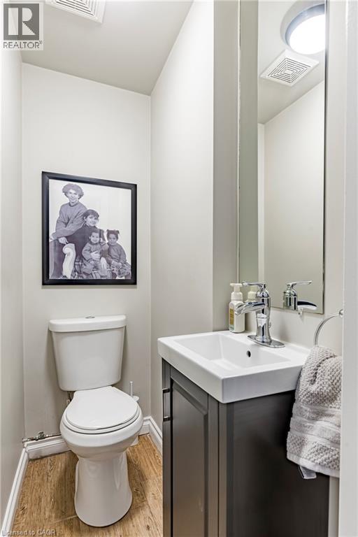 Half bathroom featuring vanity and light wood-style flooring - 58 Chatham Street, Hamilton, ON - Indoor Photo Showing Bathroom