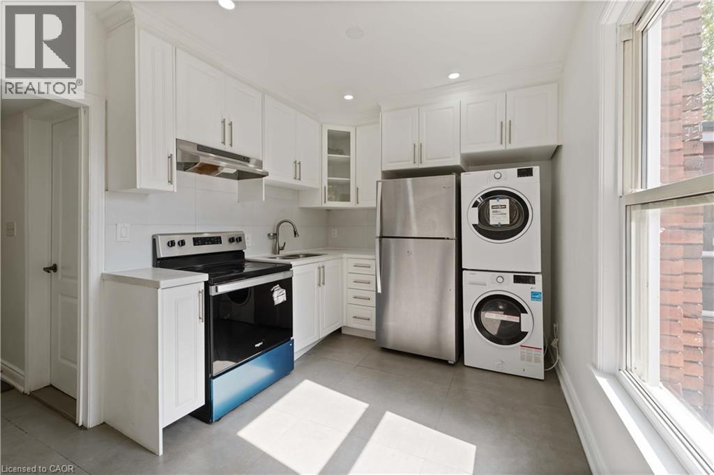 Kitchen with healthy amount of natural light, appliances with stainless steel finishes, white cabinets, light countertops, and recessed lighting - 934 Barton Street E Unit# 2, Hamilton, ON - Indoor Photo Showing Laundry Room