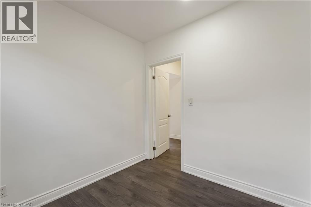 Unfurnished room featuring baseboards and dark wood finished floors - 934 Barton Street E Unit# 2, Hamilton, ON - Indoor Photo Showing Other Room