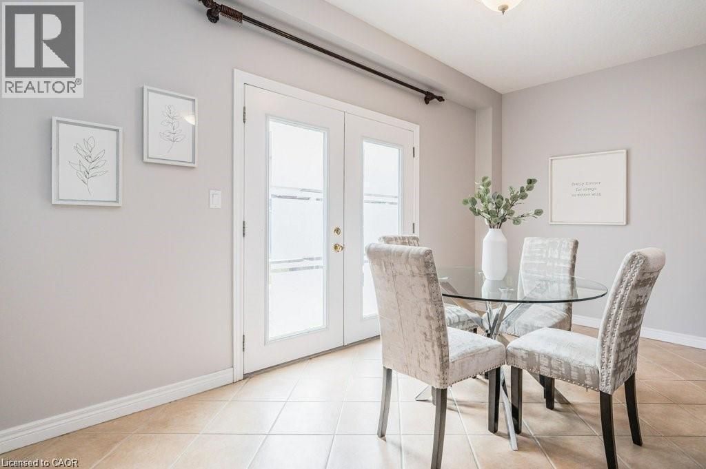 Dining area with french doors and light tile patterned floors - 609 Woolgrass Avenue, Waterloo, ON - Indoor Photo Showing Dining Room