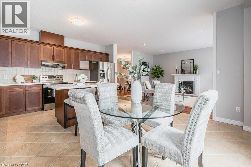 Dining area with light tile patterned floors and a fireplace - 609 Woolgrass Avenue, Waterloo, ON - Indoor Photo Showing Dining Room