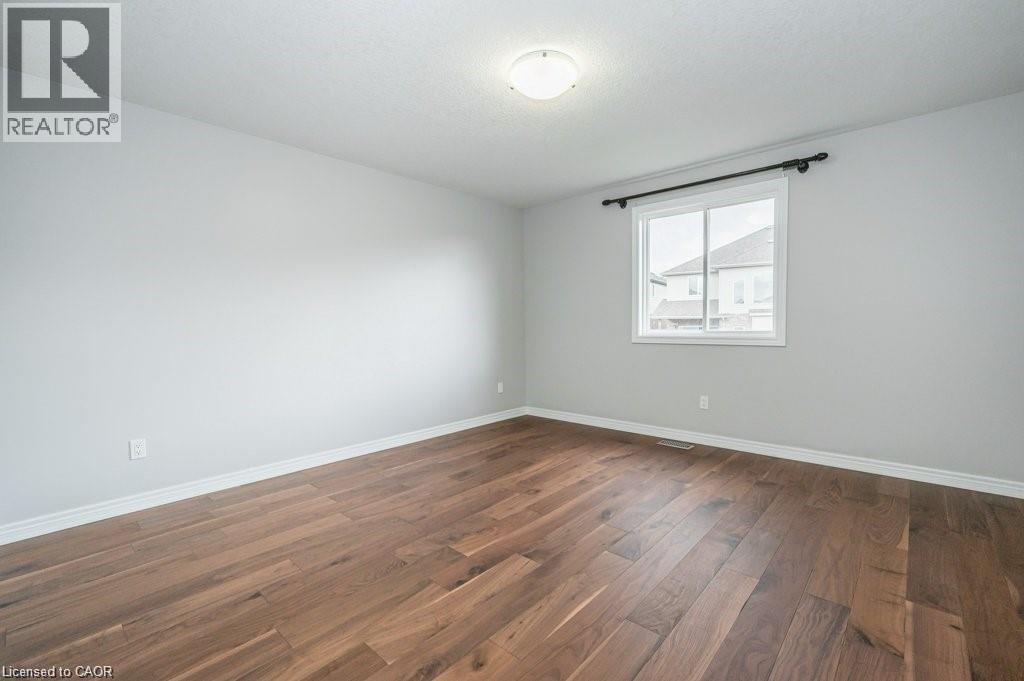Empty room with dark wood-style floors and a textured ceiling - 609 Woolgrass Avenue, Waterloo, ON - Indoor Photo Showing Other Room
