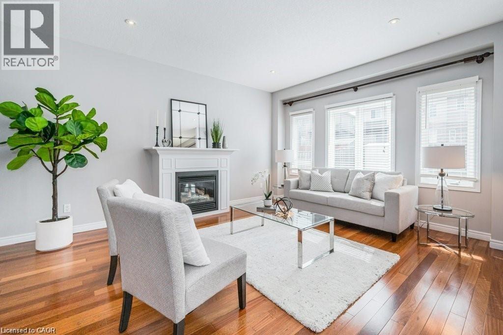 Living area with a glass covered fireplace and wood-type flooring - 609 Woolgrass Avenue, Waterloo, ON - Indoor Photo Showing Living Room With Fireplace