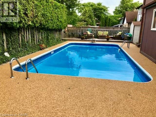 Inground pool with rubbercrete surround - 668 Tomahawk Crescent, Ancaster, ON - Outdoor With In Ground Pool With Backyard