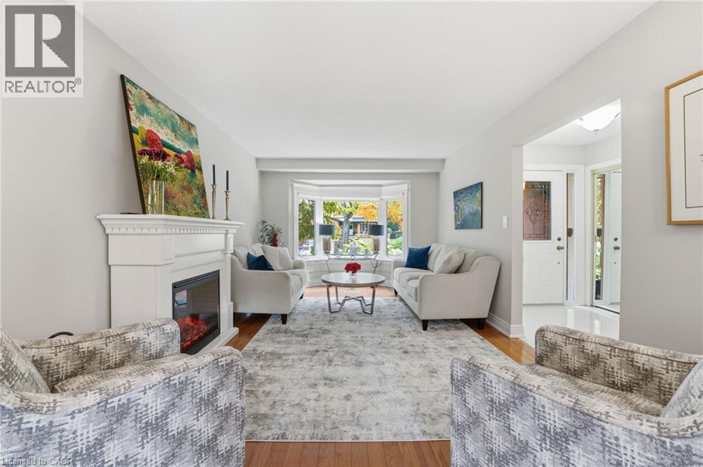 Living room with fireplace and view to front yard - 668 Tomahawk Crescent, Ancaster, ON - Indoor Photo Showing Living Room With Fireplace