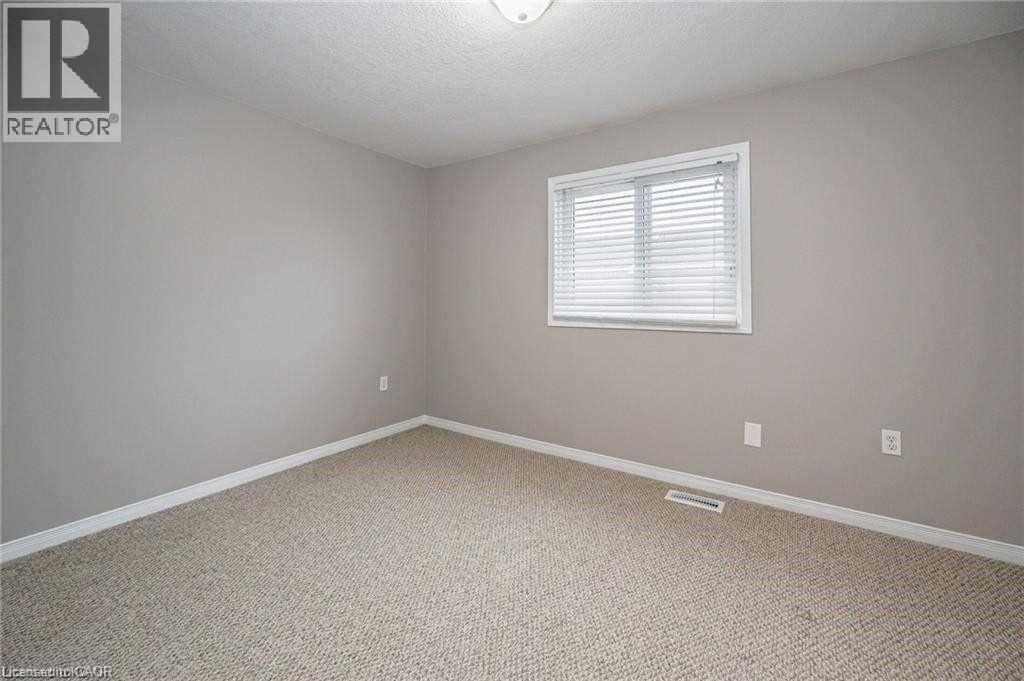 Spare room featuring carpet floors and a textured ceiling - 27 Max Becker Drive, Kitchener, ON - Indoor Photo Showing Other Room