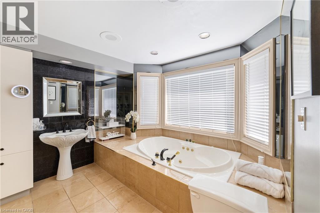 Soaker jet tub, oversized windows, added cabinet for linen storage, recessed lighting - 7775 St. Augustine Crescent, Niagara Falls, ON - Indoor Photo Showing Bathroom