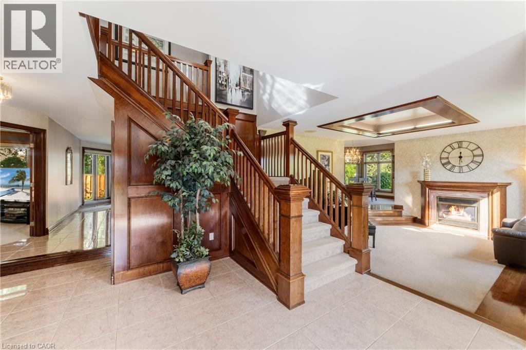 Front foyer, tile with wide staircase and solid wood banister - 7775 St. Augustine Crescent, Niagara Falls, ON - Indoor Photo Showing Other Room With Fireplace