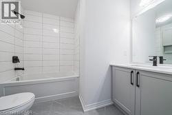 Bathroom featuring shower / tub combination, vanity, and light marble finish floors -