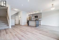 Kitchen featuring open floor plan, gray cabinetry, dark countertops, backsplash, and recessed lighting -
