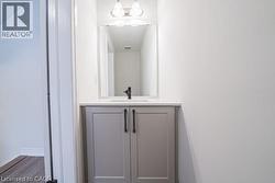 Half bath with vanity and wood finished floors -