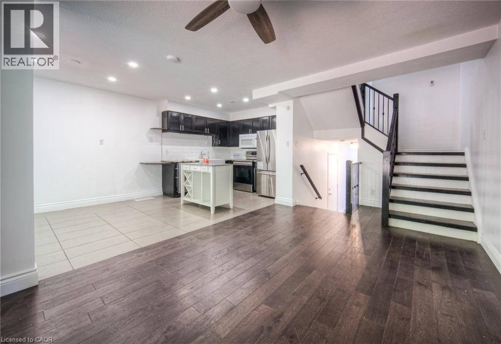 Unfurnished living room featuring stairway, a ceiling fan, recessed lighting, and light wood-type flooring - 20 Bankside Drive, Kitchener, ON - Indoor Photo Showing Kitchen