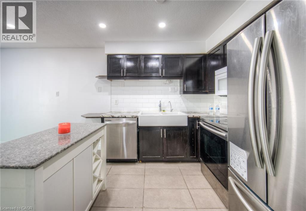 Kitchen featuring appliances with stainless steel finishes, open shelves, recessed lighting, light stone counters, and light tile patterned floors - 20 Bankside Drive, Kitchener, ON - Indoor Photo Showing Kitchen With Upgraded Kitchen