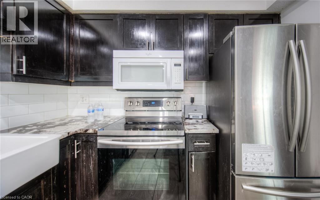 Kitchen featuring appliances with stainless steel finishes, tasteful backsplash, and light stone counters - 20 Bankside Drive, Kitchener, ON - Indoor Photo Showing Kitchen With Upgraded Kitchen