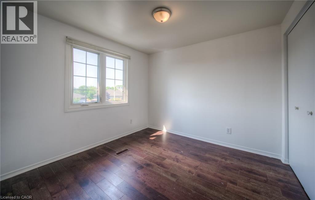 Unfurnished bedroom with dark wood-style floors and a closet - 20 Bankside Drive, Kitchener, ON - Indoor Photo Showing Other Room