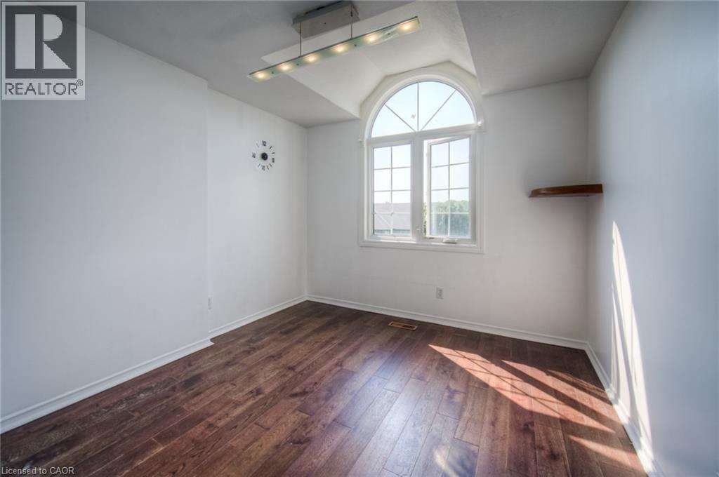 Empty room featuring vaulted ceiling and dark wood finished floors - 20 Bankside Drive, Kitchener, ON - Indoor Photo Showing Other Room